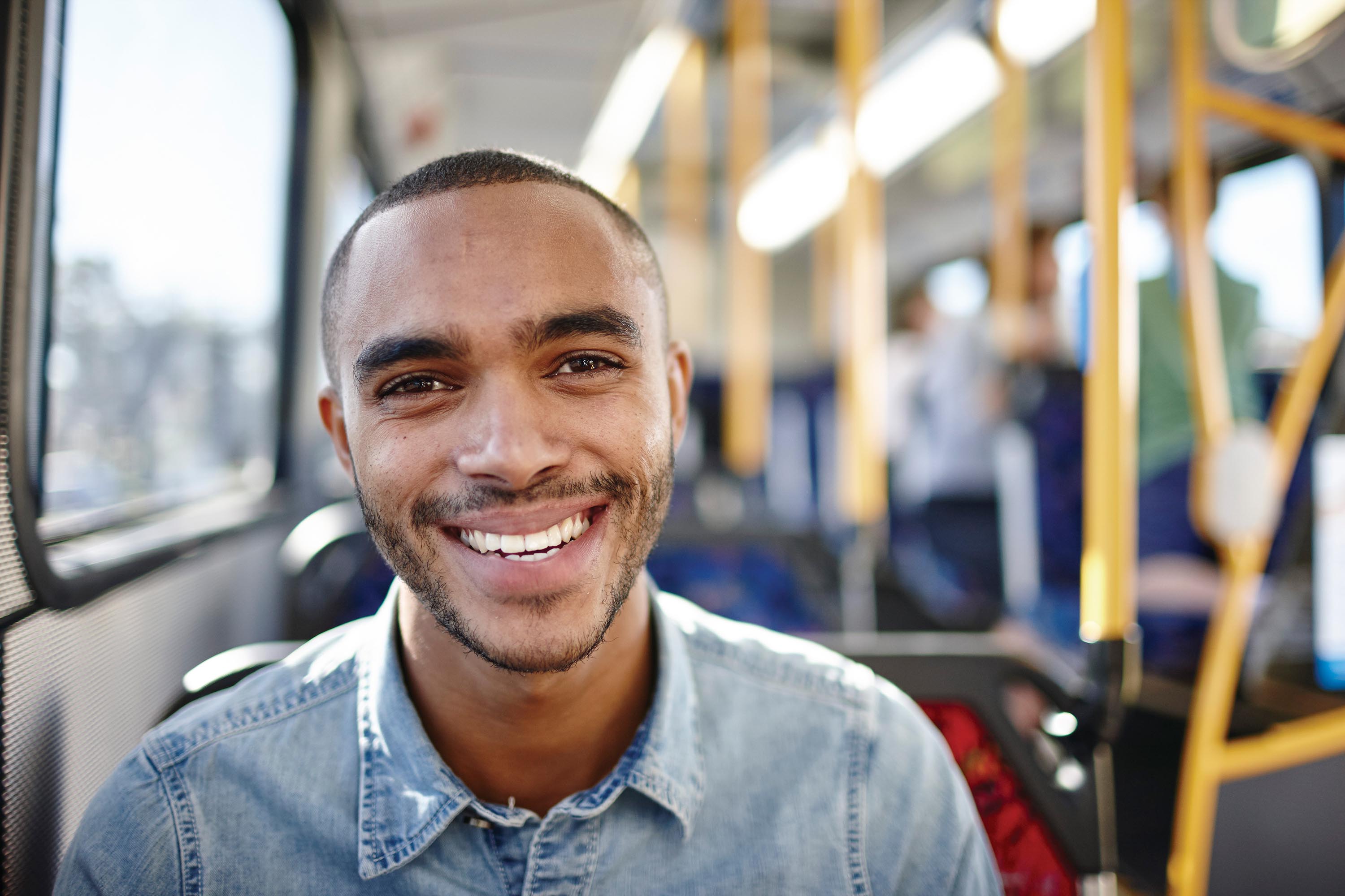 young adult man on bus close up face smiling blue shirt