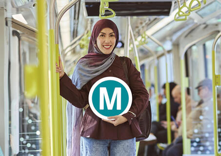 Transport for NSW Metro passenger holding signage inside carriage.