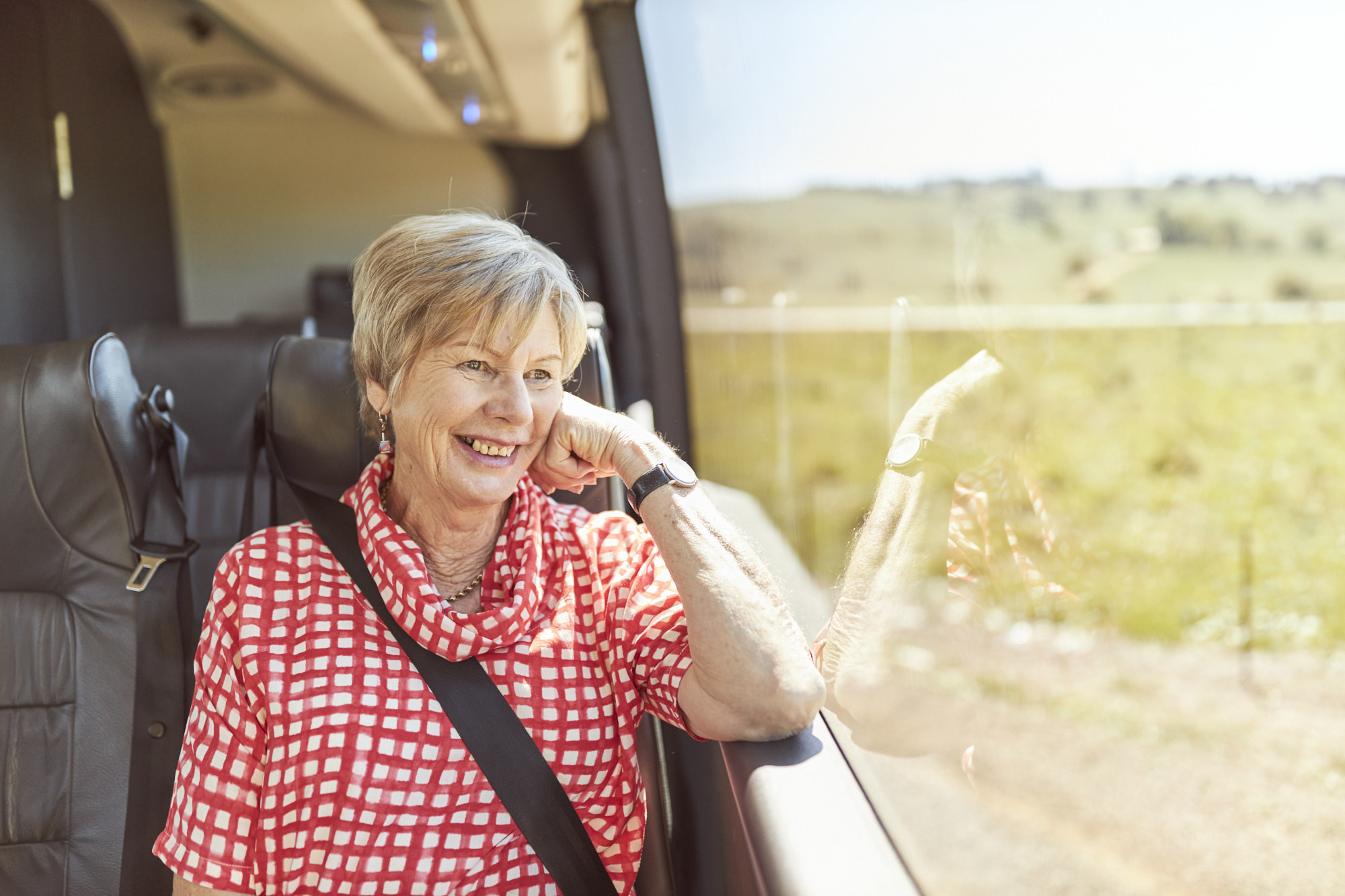 Smiling passenger looking out of the window.