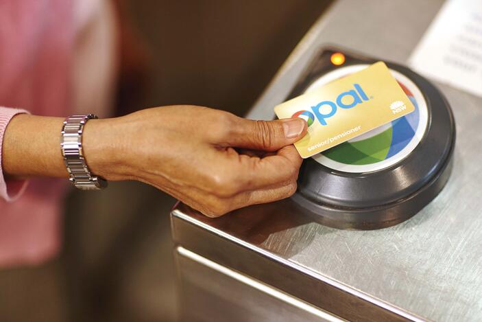 female hand tapping gold senior pensioner opal card