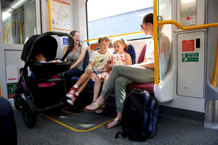 Mothers with prams and small children seated on a train