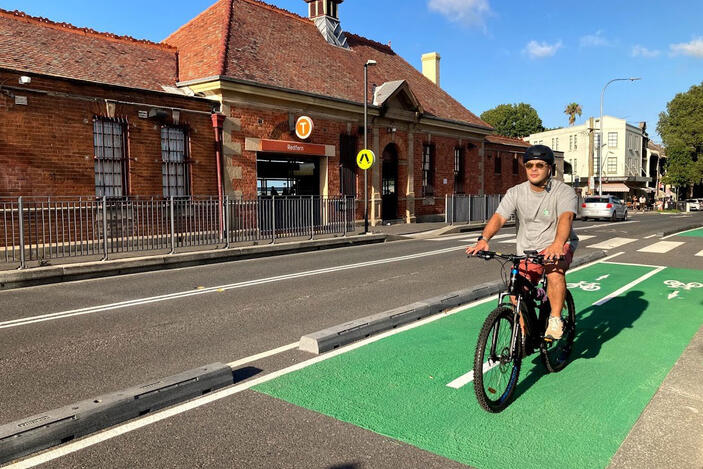 Man rides bike on green cycling route near Redfern train station