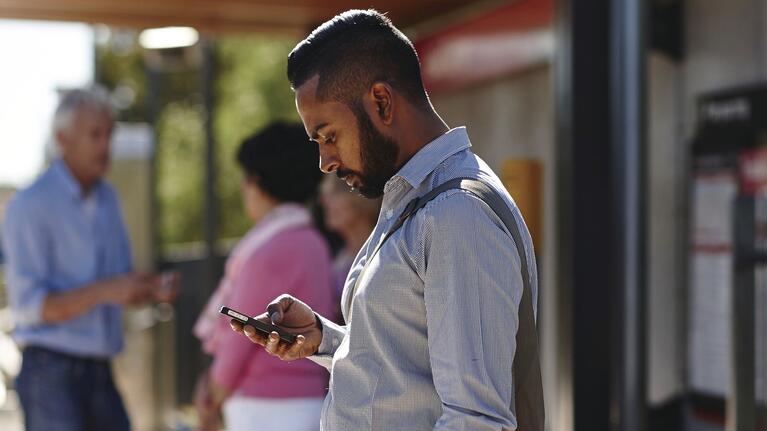 A man uses the transport real-time travel app on his phone
