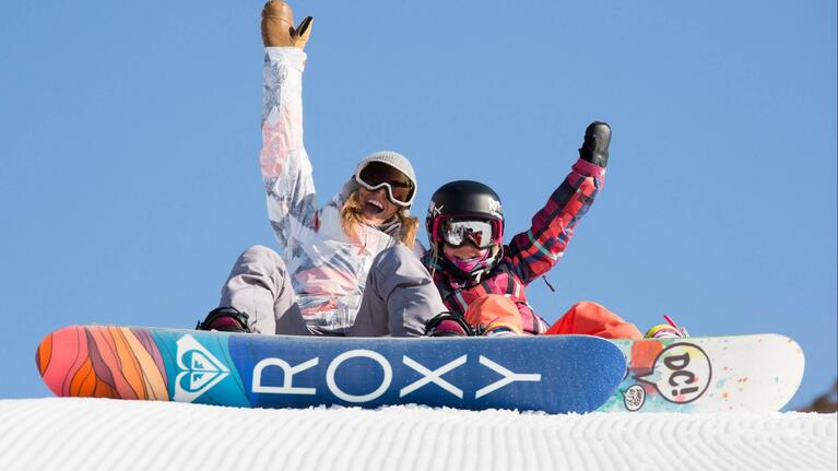 Two snowboarders prepare to start a race