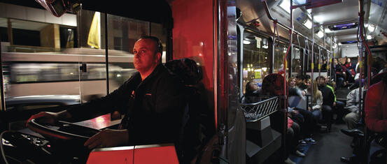 Inside a bus at night time with the driver and passengers