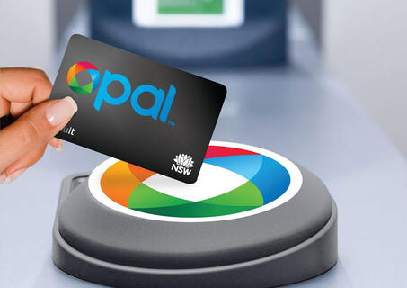 Adult Opal card tapping on an Opal card reader